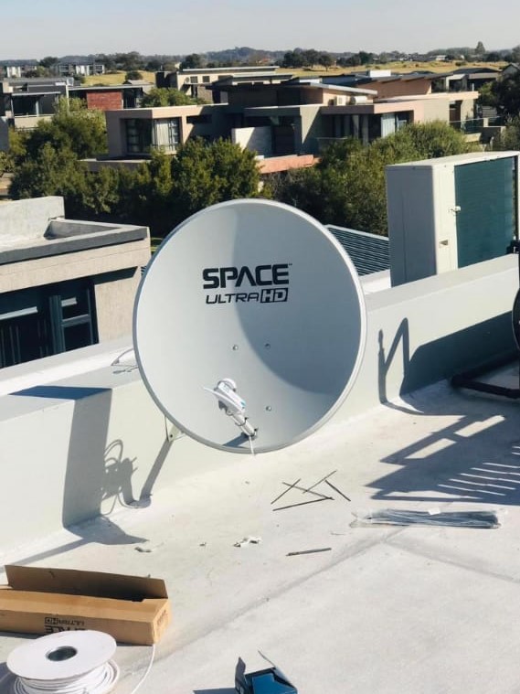 Ultra HD satellite dish mounted on a flat roof in an estate